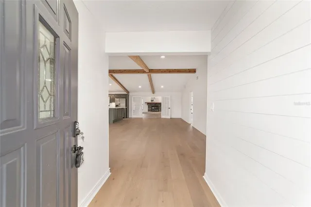 an empty room with windows and fireplace