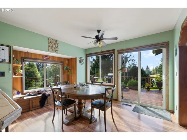 a dining room with furniture large windows and a chandelier