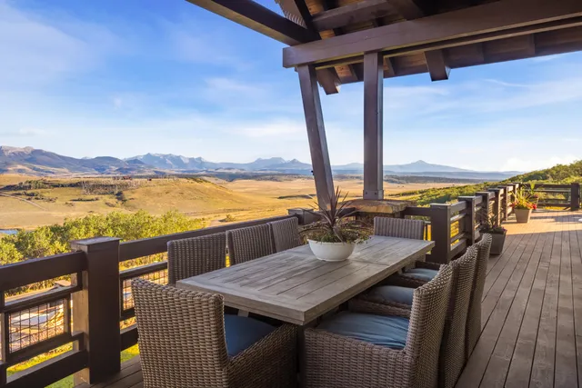 a living room with furniture a large window with kitchen view