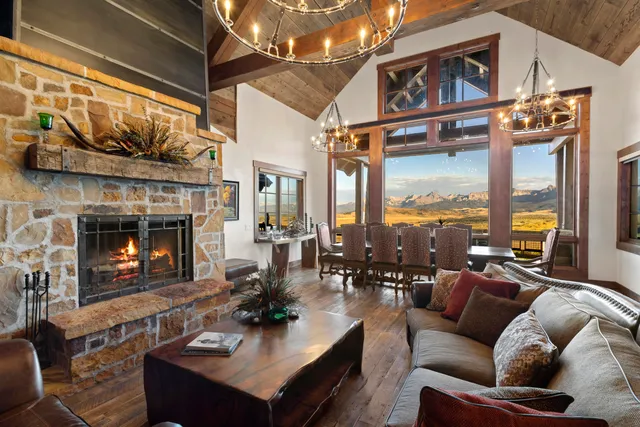 a living room with furniture a fireplace a large window and palm tree