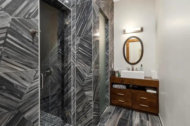 a view of a house with a barbeque and wooden fence