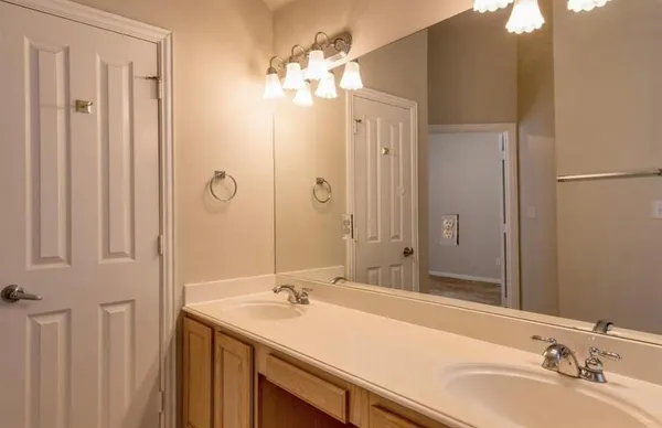 a bathroom with a double vanity sink and a mirror