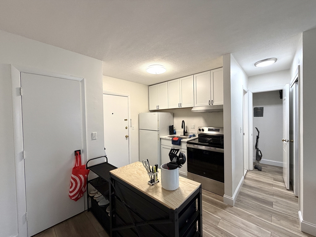 720 Bennington Street, Unit 207 Boston, MA 02128 - Photo 4 of 9 a kitchen with stainless steel appliances granite countertop a refrigerator stove and sink