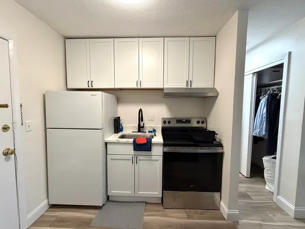 a kitchen with a refrigerator and a stove