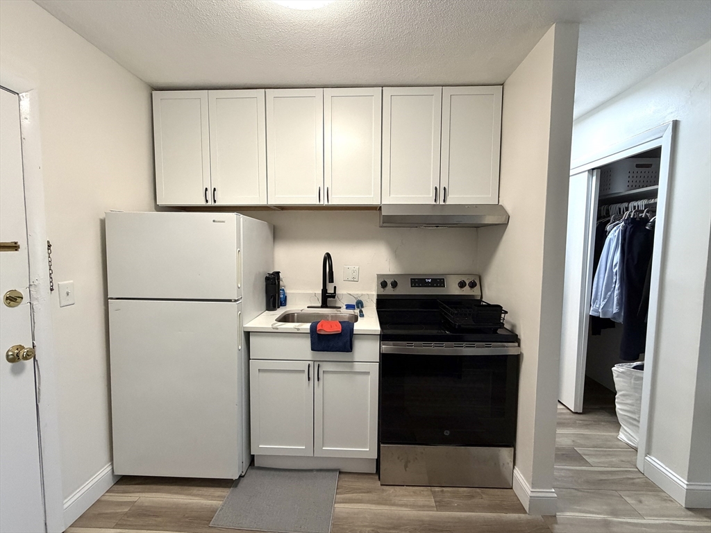 720 Bennington Street, Unit 207 Boston, MA 02128 - Photo 5 of 9 a kitchen with a refrigerator and a stove