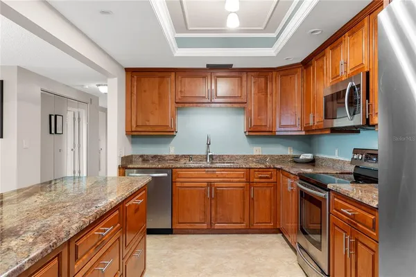 a kitchen with stainless steel appliances granite countertop a refrigerator and a sink