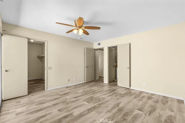 an empty room with a window and a fan