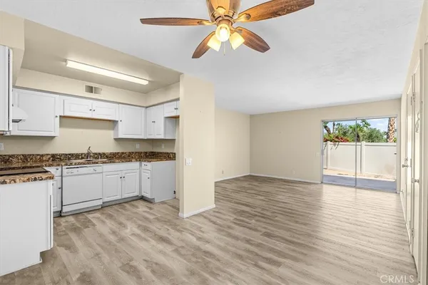 a kitchen with granite countertop a sink a stove and cabinets