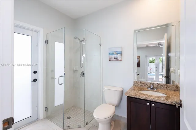 a bathroom with a granite countertop sink toilet and shower
