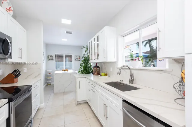 a kitchen with a sink a stove and cabinets