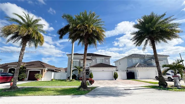 a view of a house with a yard and palm trees