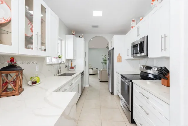 a kitchen with a sink a stove and cabinets