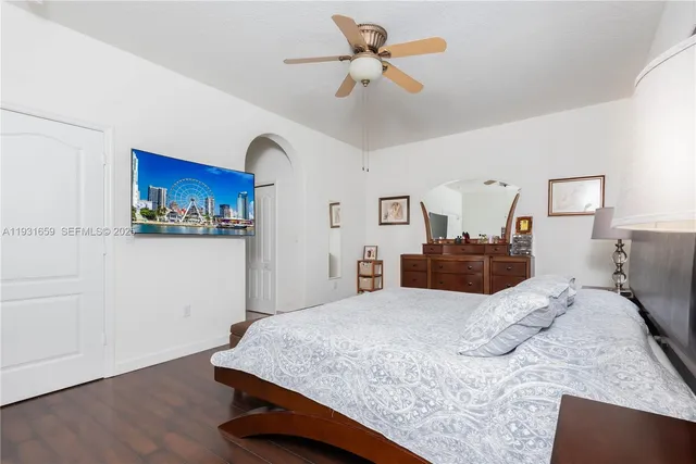a bedroom with a large bed and wooden floor