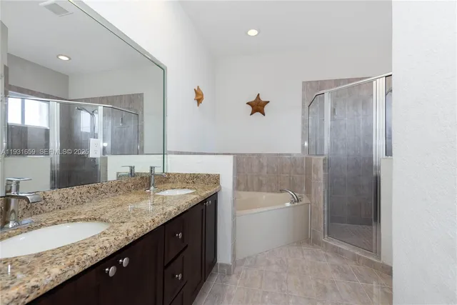 a bathroom with a granite countertop bathtub sink vanity and mirror