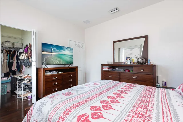 a bedroom with a bed and a mirror on dresser