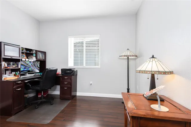 a view of a workspace with furniture and a window