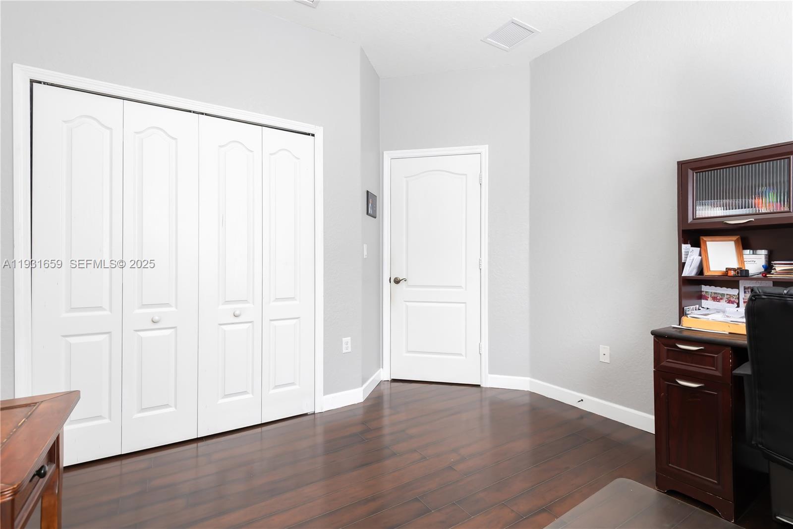 18361 Southwest 154th Avenue Miami, FL 33187 - Photo 39 of 48 an empty room with wooden floor closet and windows