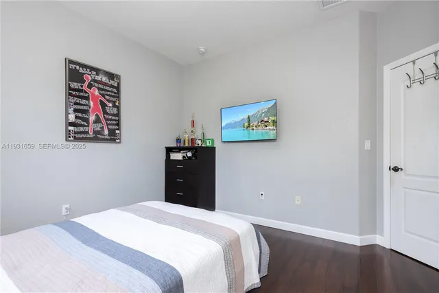 a bedroom with a bed and wooden floor