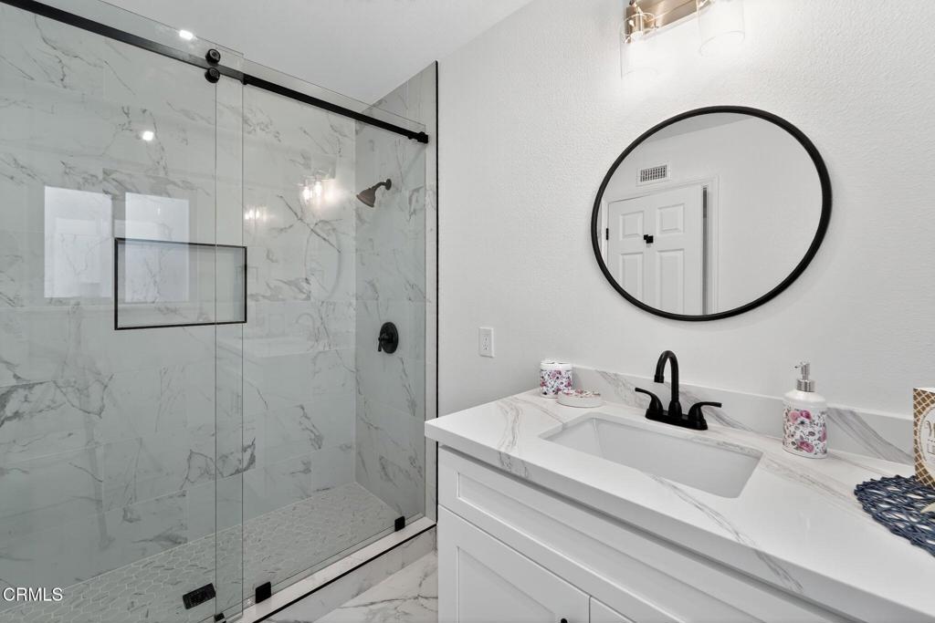 2848 Jadestone Avenue Simi Valley, CA 93063 - Photo 19 of 31 a bathroom with a sink a glass door and a mirror