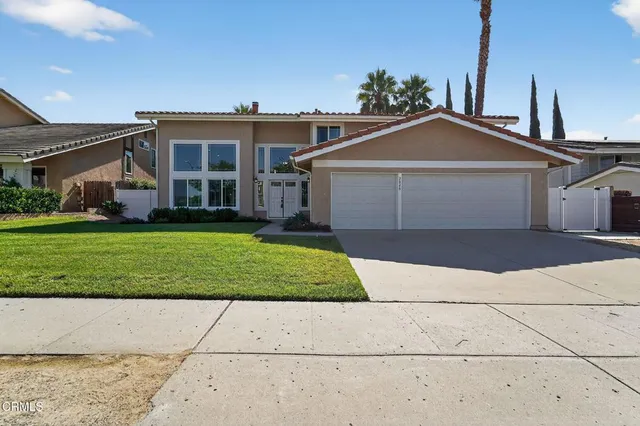 a front view of a house with a yard and garage