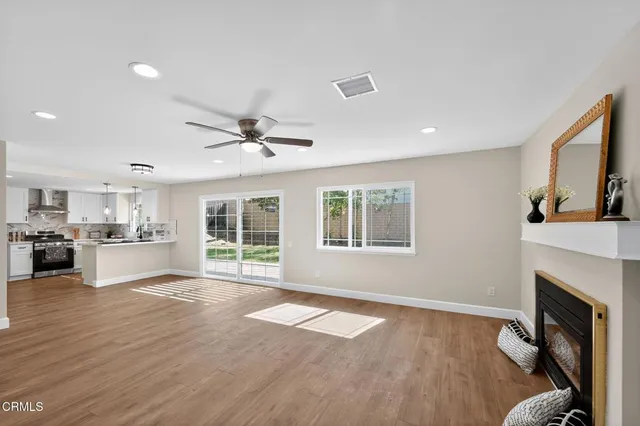 a view of an empty room with a window and fireplace