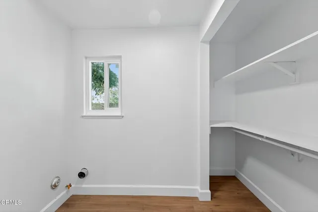 an empty room with windows and fireplace