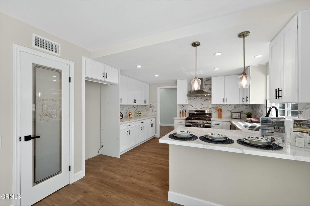 2848 Jadestone Avenue Simi Valley, CA 93063 - Photo 10 of 31 a kitchen with kitchen island a refrigerator a stove a sink and white cabinets
