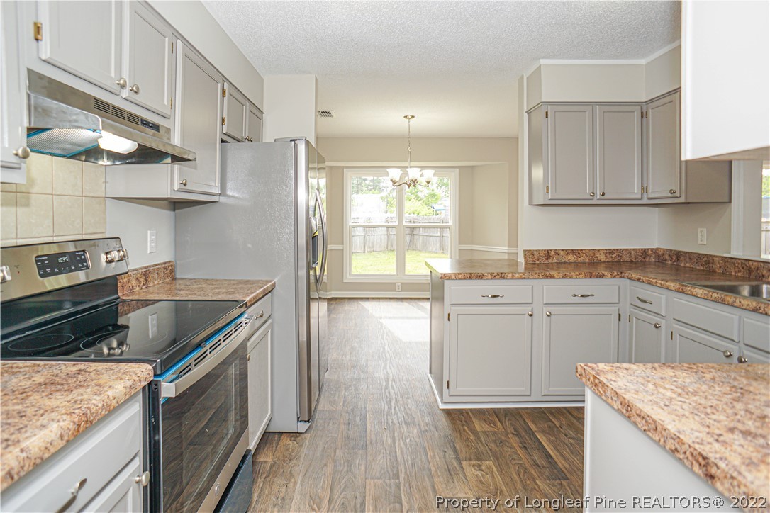 974 Rim Road Fayetteville, NC 28314 - Photo 15 of 40 a kitchen with a stove sink and cabinets