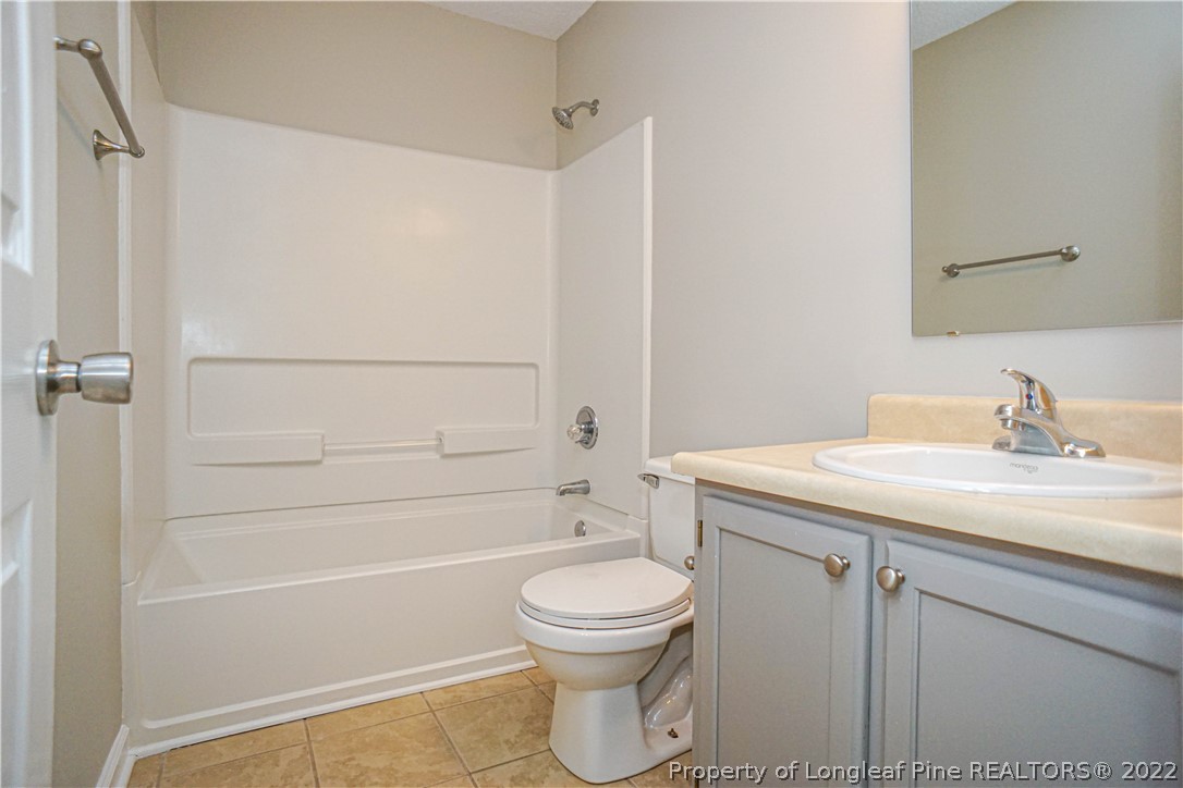 974 Rim Road Fayetteville, NC 28314 - Photo 17 of 40 a bathroom with a granite countertop toilet a sink and a bathtub
