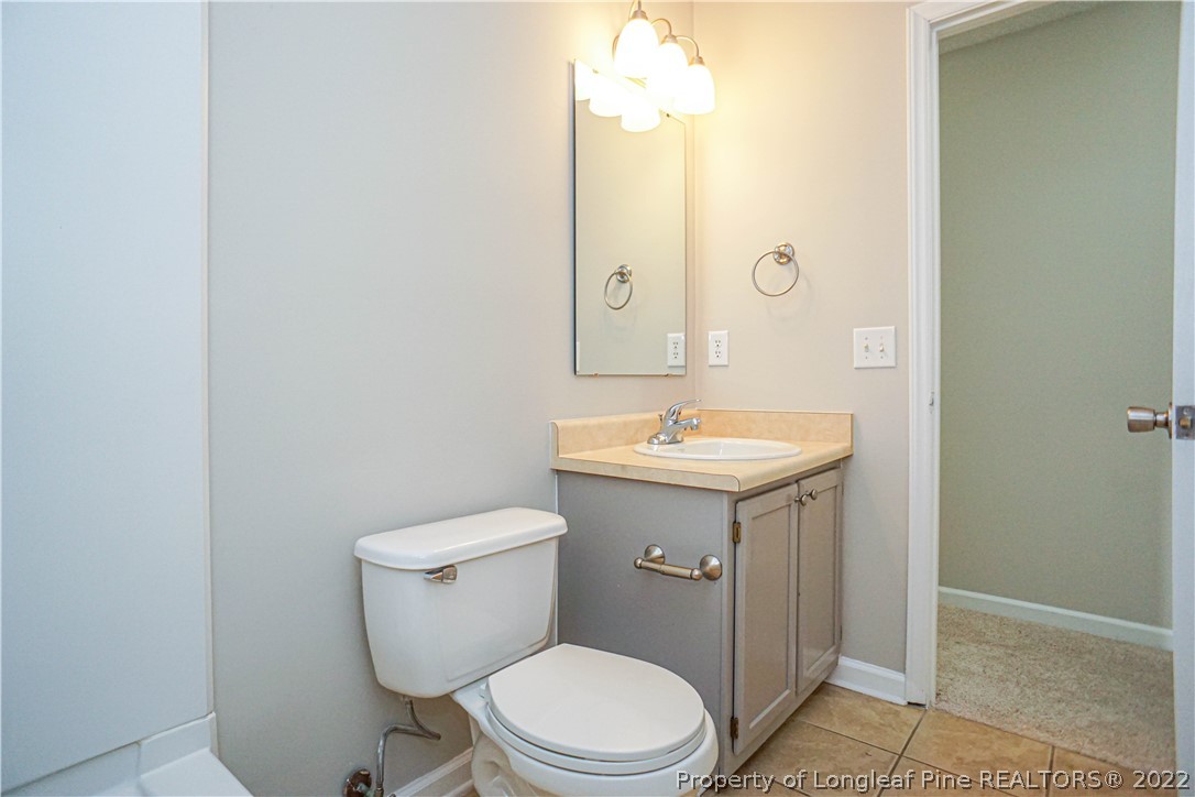 974 Rim Road Fayetteville, NC 28314 - Photo 18 of 40 a bathroom with a sink a toilet and mirror