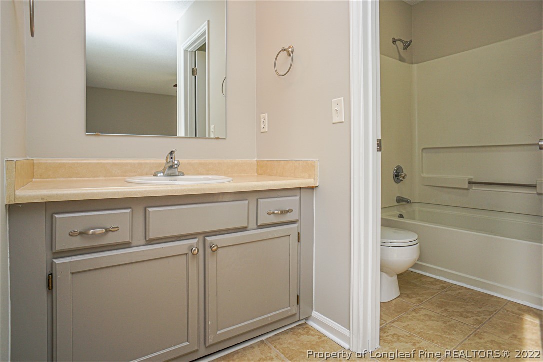974 Rim Road Fayetteville, NC 28314 - Photo 32 of 40 a bathroom with a granite countertop toilet sink and mirror