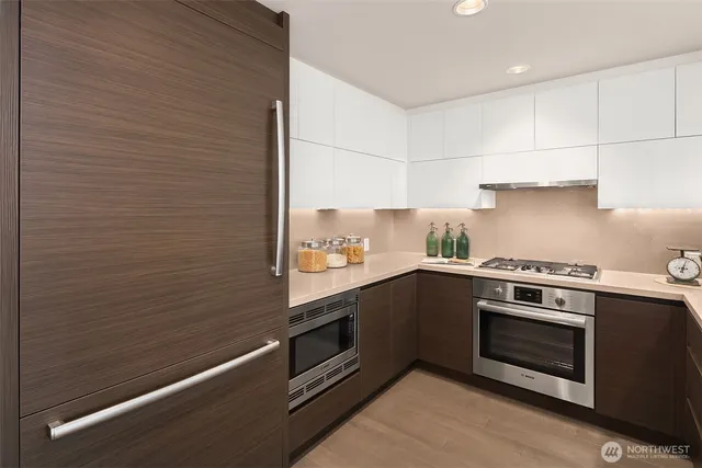 a kitchen with stainless steel appliances wooden cabinets and stove top oven