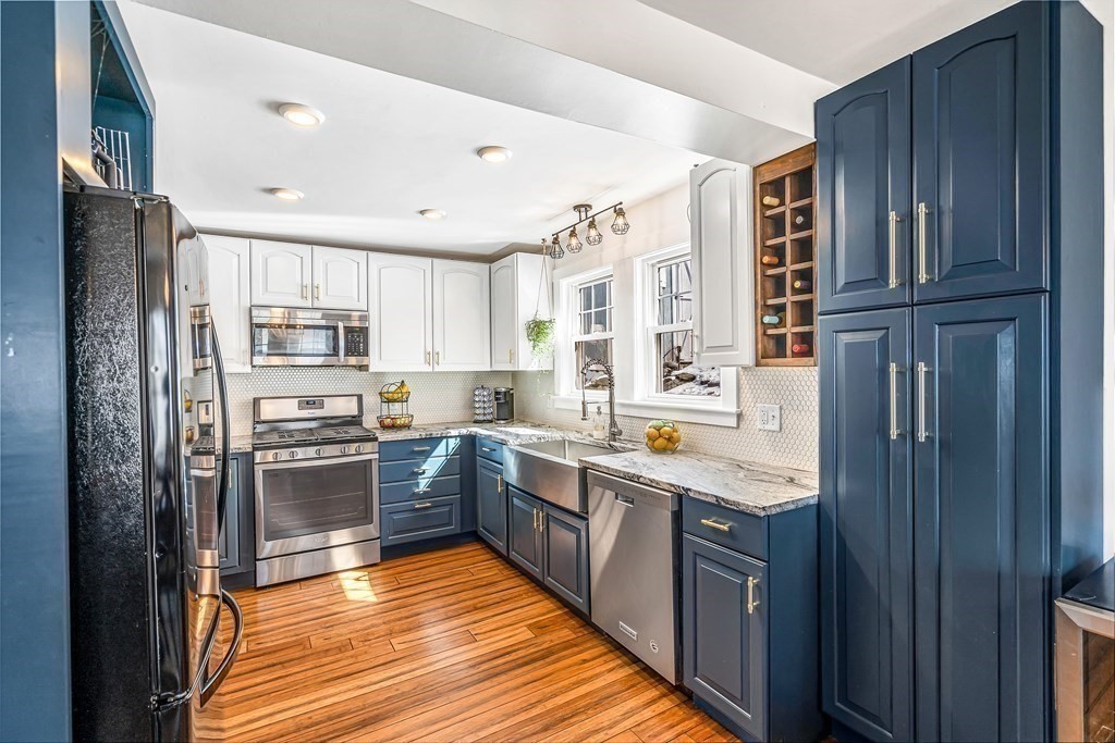 37 Acre Street Clinton, MA 01510 - Photo 18 of 38 a kitchen with stainless steel appliances granite countertop refrigerator a sink dishwasher a stove top oven a kitchen island and cabinets with wooden floor