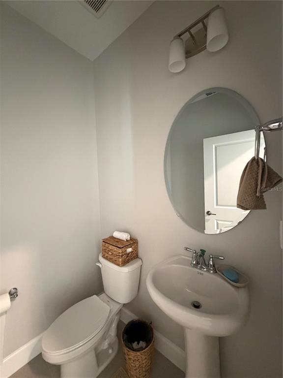 1389 Lumpini Street St. Cloud, FL 34771 - Photo 11 of 32 a bathroom with a toilet sink and mirror