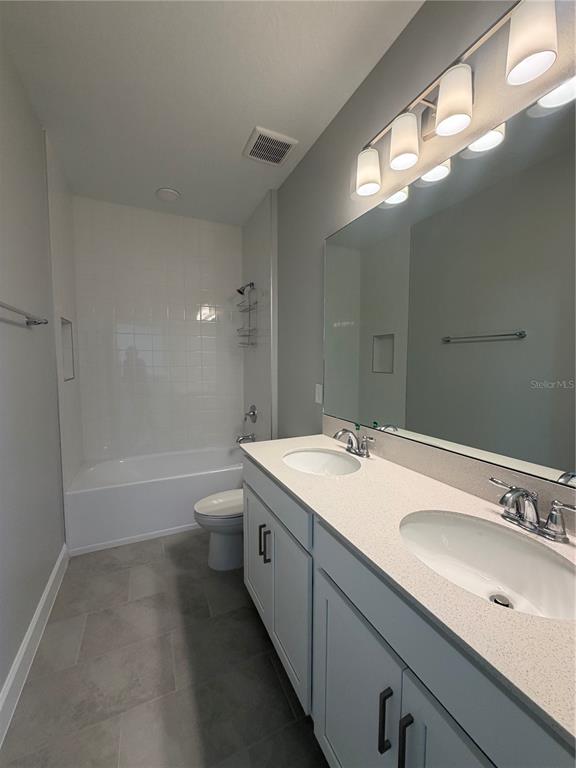 1389 Lumpini Street St. Cloud, FL 34771 - Photo 20 of 32 a bathroom with a granite countertop sink a toilet and bathtub