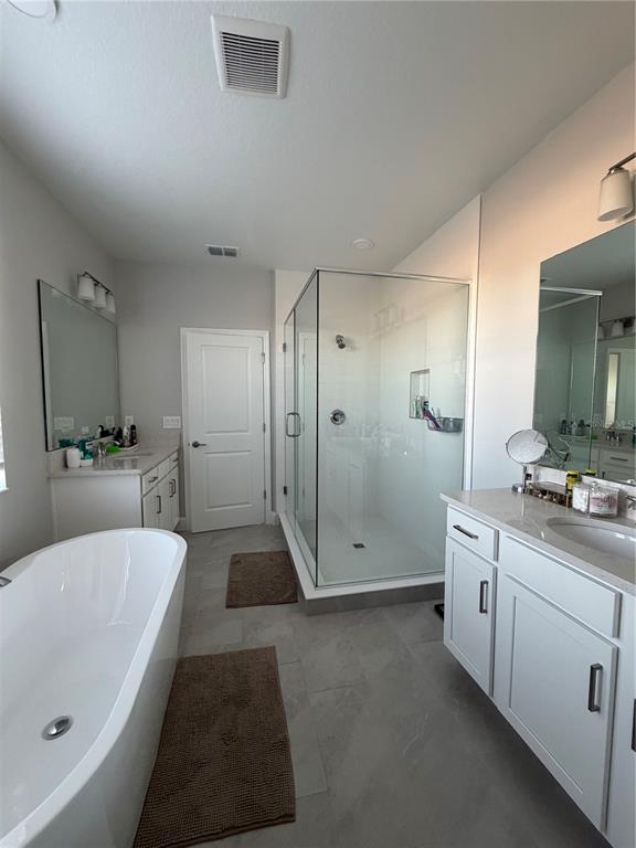 1389 Lumpini Street St. Cloud, FL 34771 - Photo 28 of 32 a large bathroom with a tub a sink shower and mirror