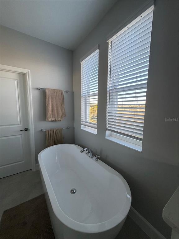 1389 Lumpini Street St. Cloud, FL 34771 - Photo 29 of 32 a bathroom with a tub and a window