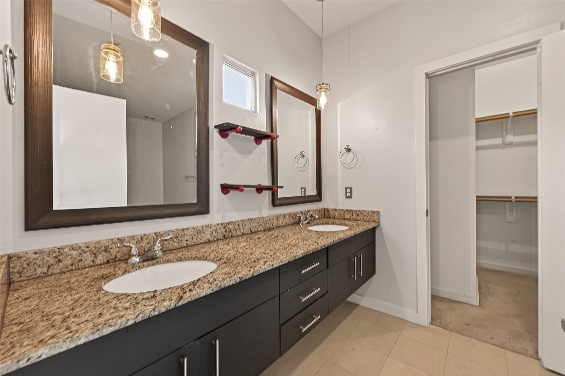1112 Columbus Street, Unit B Houston, TX 77019 - Photo 24 of 31 a bathroom with a granite countertop double vanity sink and a mirror