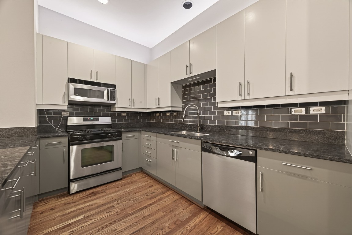 1112 Columbus Street, Unit B Houston, TX 77019 - Photo 6 of 31 a kitchen with granite countertop a stove sink and cabinets