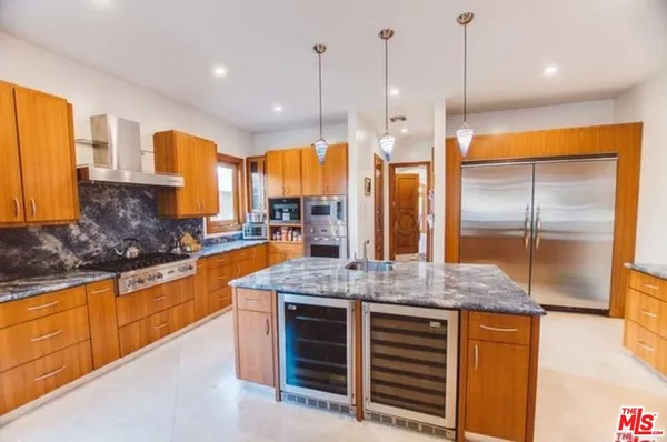 a kitchen with stainless steel appliances granite countertop a stove a sink and a refrigerator
