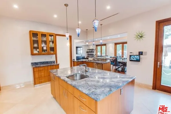a kitchen with stainless steel appliances granite countertop a sink a refrigerator and a stove