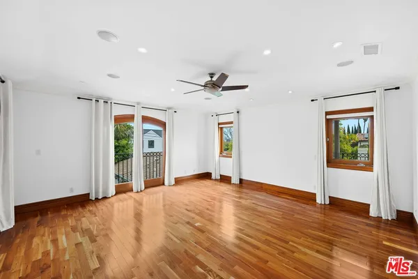 a view of a livingroom with wooden floor and a ceiling fan