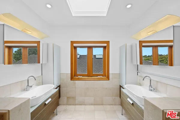 a bathroom with a granite countertop double vanity sink a mirror and a bathtub