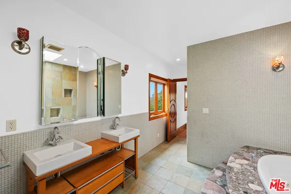 a spacious bathroom with a granite countertop sink and a mirror