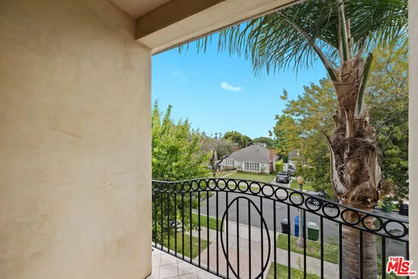 a view of an empty room with wooden floor and a bathroom