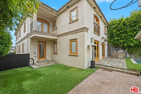 a front view of a house with a yard and potted plants