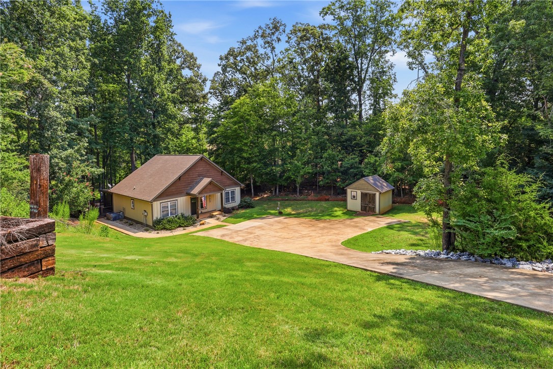1110 Sunset Lane Anderson, SC 29626 - Photo 30 of 38 A private driveway leads to this charming home nestled amidst a verdant, wooded landscape, complete with a detached shed.