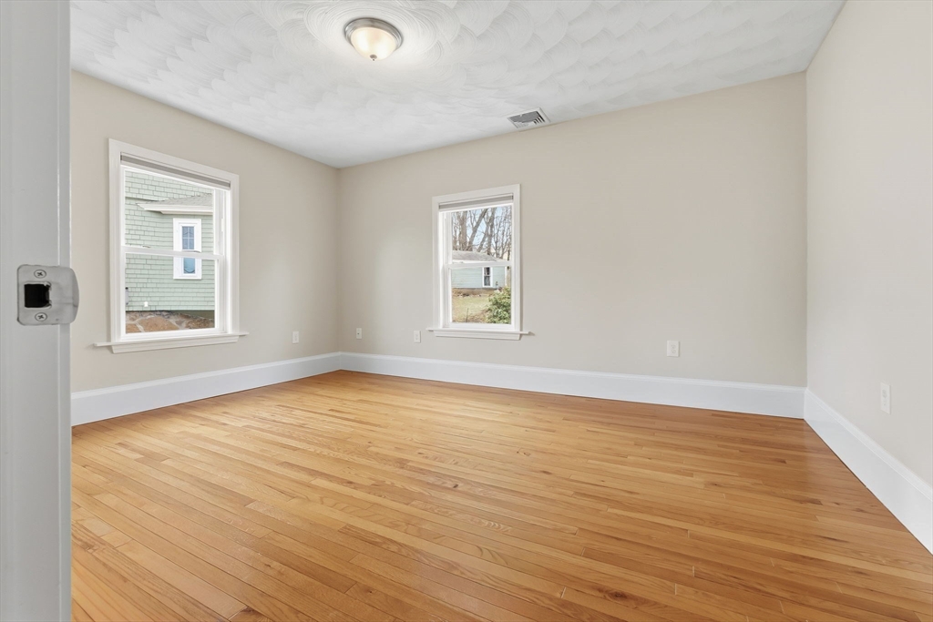 5 Pickett Street Beverly, MA 01915 - Photo 8 of 30 an empty room with wooden floor and windows