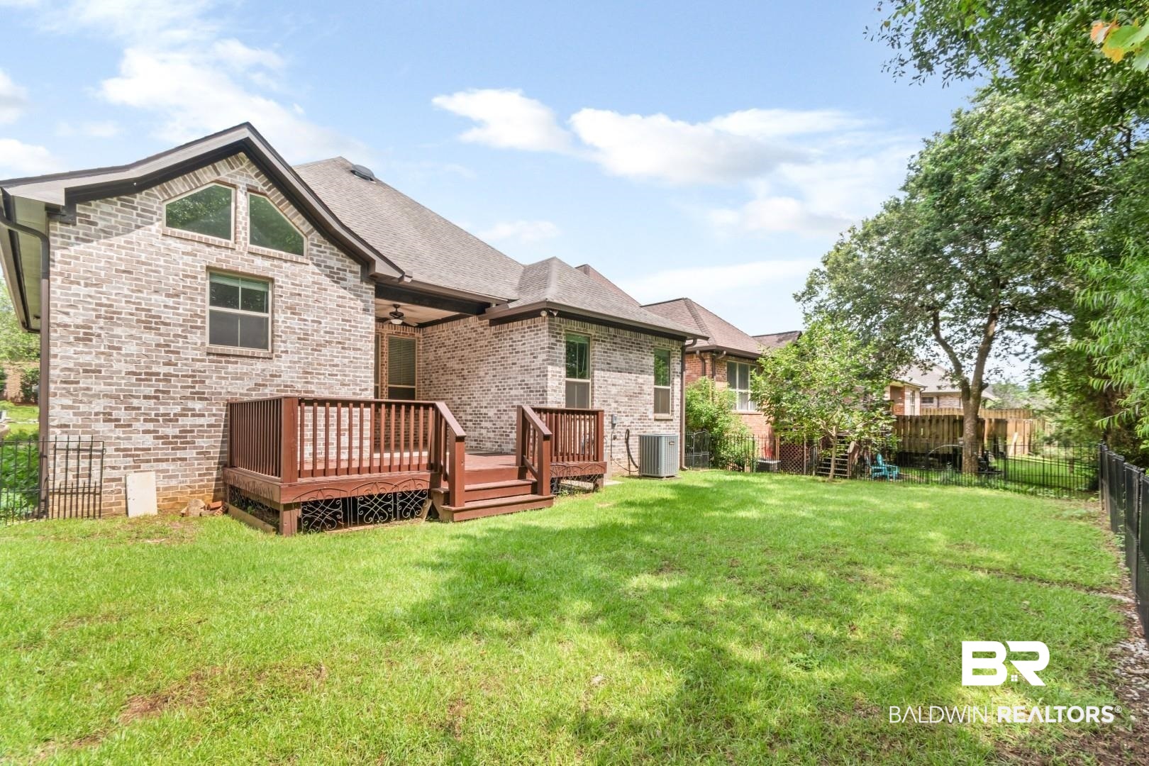 3528 Rue Royal Mobile, AL 36693 - Photo 45 of 53 Expansive backyard featuring a manicured lawn, mature trees, and a black metal fence