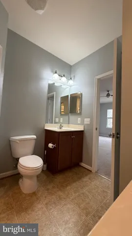 a bathroom with a sink toilet mirror and vanity
